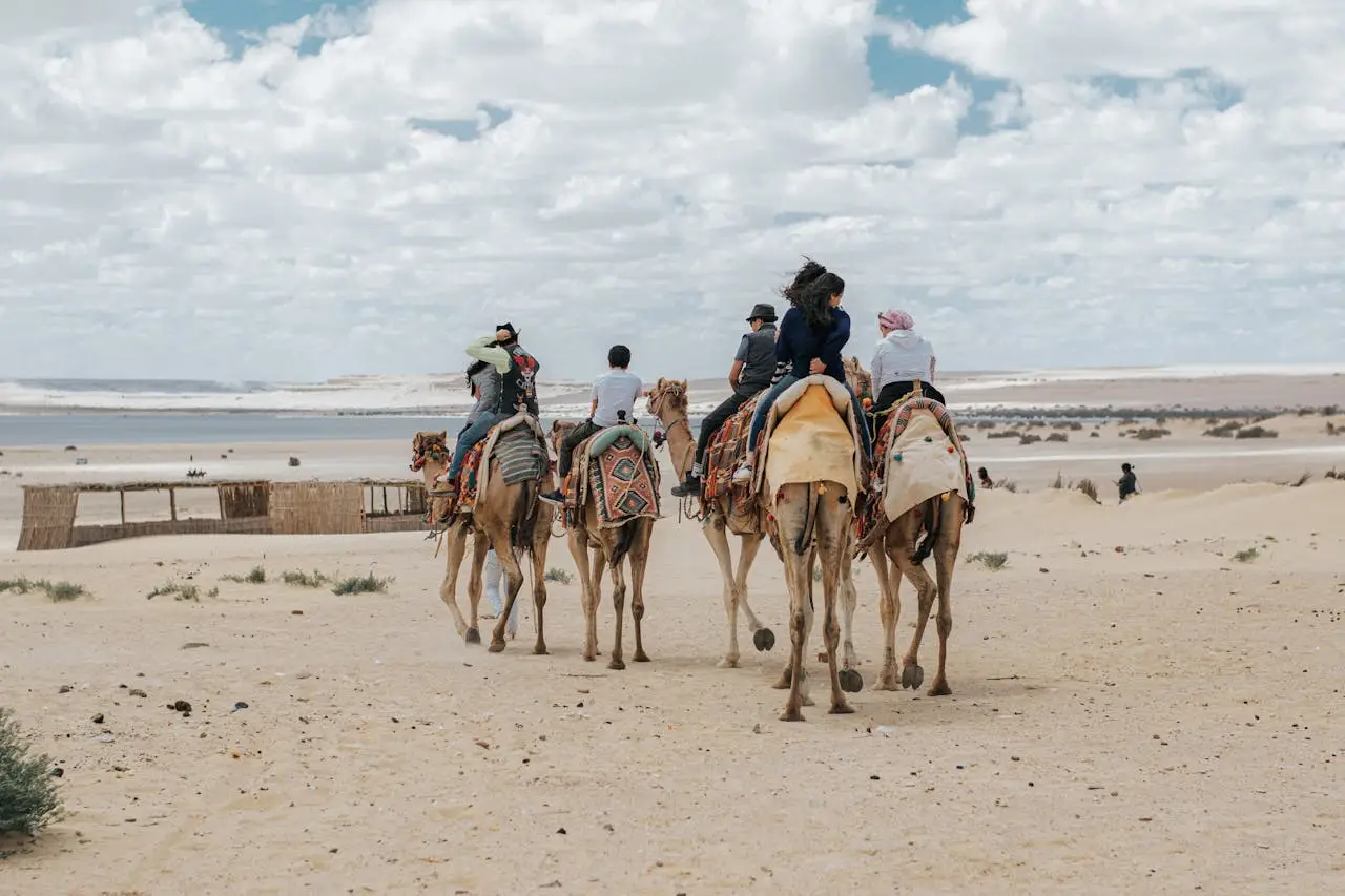 People Riding Camels in the Desert 